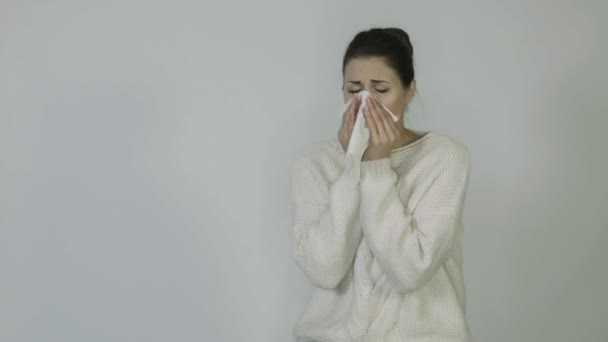 Chica aislada sobre un fondo blanco con una temperatura estornuda — Vídeos de Stock