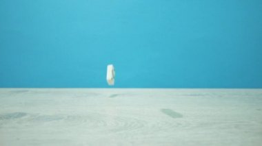 Masmavi bir arka plan üzerinde beyaz Domino yavaş devinim atış düşmek