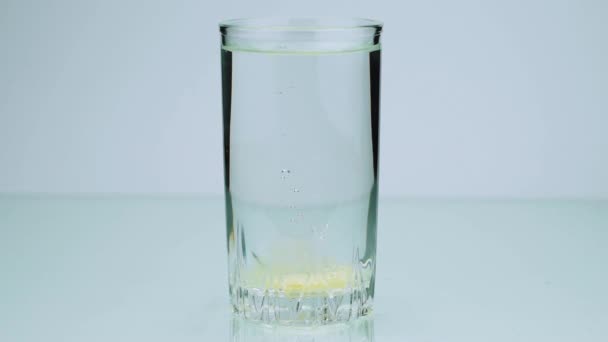 Une pilule effervescente dissout l'aspirine au ralenti sur un fond coloré 