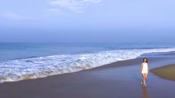 Luftaufnahme, wie das Mädchen allein am Strand des tropischen Landes spaziert — Stockvideo