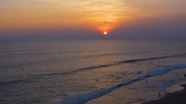 Tropical sunset. The sun sets over the ocean, the sea waves in the evening light, drone flyes over the beach — Stock Video