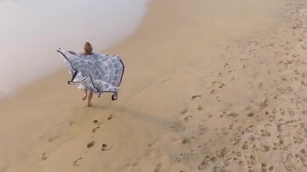 Câmera lenta aérea tiro menina feliz correndo ao longo da costa do oceano em trópicos — Vídeo de Stock