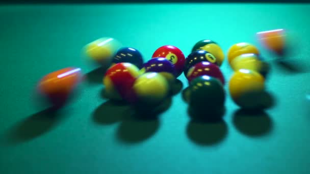 Multi-colored billiard balls roll in different directions from blow with a cue. — Stockvideo