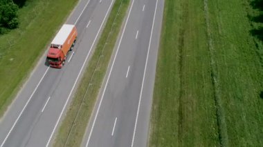 Kamyonlar yol boyunca gidiyor. Orman bölgesinde uzun bir otoyol