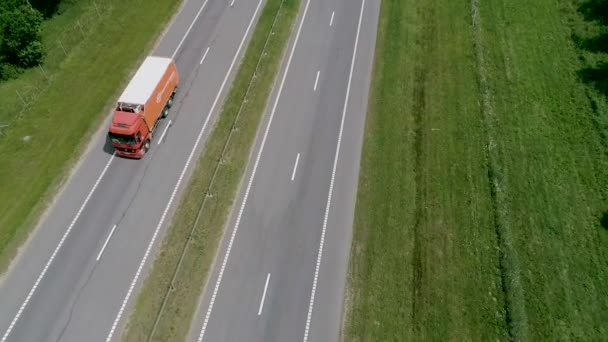 Φορτηγά οδηγούν κατά μήκος του δρόμου. Ένας μακρύς αυτοκινητόδρομος μέσα από μια δασική περιοχή — Αρχείο Βίντεο
