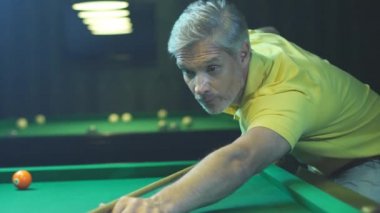 Beyaz saçlı yetişkin bilardo oynar. Otelde boş vakit. Yüzü yakın çekim.