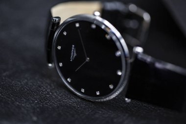 Saint-Imier, İsviçre, 2.02.2020 - Longines siyah çelik gövde deri kayışlı saat yakın çekim yüzlü bir yüzey makro. Longines İsviçreli lüks saatçi, Swatch grubunun bir parçası..