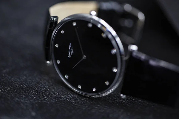 Saint-Imier, İsviçre, 2.02.2020 - Longines siyah çelik gövde deri kayışlı saat yakın çekim yüzlü bir yüzey makro. Longines İsviçreli lüks saatçi, Swatch grubunun bir parçası..