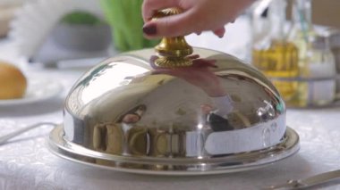 Garson yemek için lüks, parlak bir Cloche açıyor..