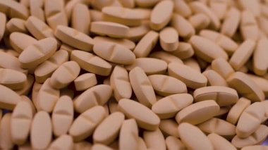 Beyaz antipiretik kapsüller parlak turuncu antibiyotiklerin üzerine düşüyor.