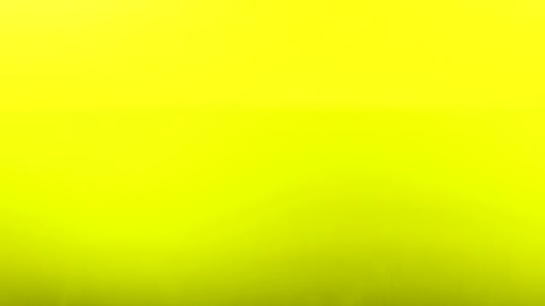 Капля воды падает на поверхность жидкости на медленном ярко-желтом фоне — стоковое видео