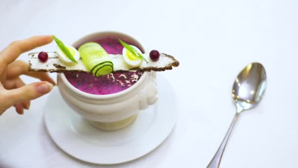 Sopa fría se pone en una mesa con un mantel blanco en un restaurante . — Vídeo de stock