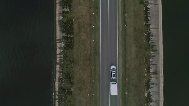 Auto s karavanem jede po silnici přes řeku v Kanadě. Rodinný výlet — Stock video
