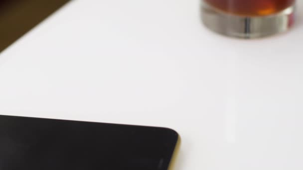 Een man zet een duur Zwitsers horloge op een witte tafel. — Stockvideo