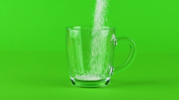 Pour sugar mug glass thick bottom green contrasting background slow motion — Stock Video