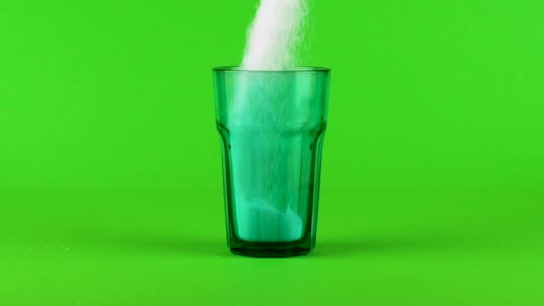 Залить сахар зеленый Коллинз стекло толстое дно зеленый фон замедленной съемки — стоковое видео