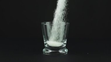 Şekerli bardak, kalın alt, siyah zıt zıt arka plan, yavaş çekim.