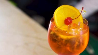 Aperol Spritz üretme süreci. Barmen kokteylin içine pipet koyar..