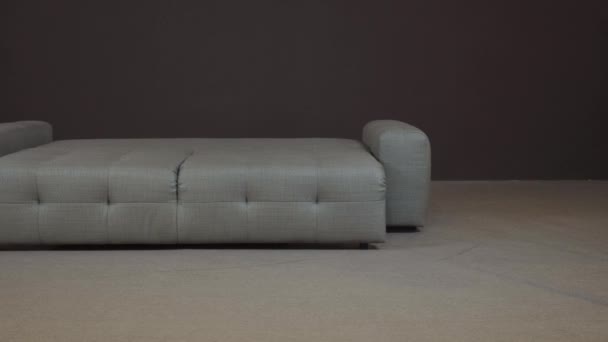 Elegante sofá gris de lujo está dispuesto en una cama doble con un colchón ortopédico — Vídeos de Stock