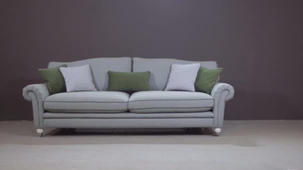 Minimalistisches graues Sofa mit dekorativen grünen Kissen aus natürlichem Füllstoff — Stockvideo