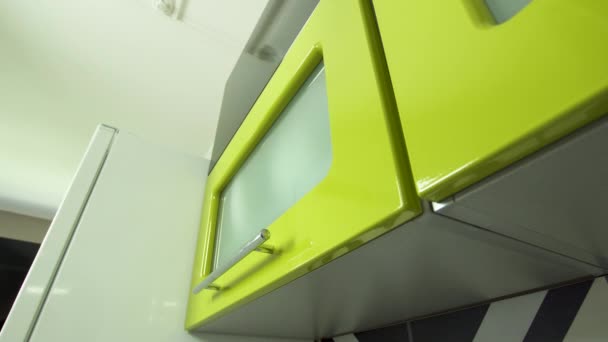 Zielone szklane drzwi szafki kuchennej otwierają się płynnie i automatycznie. — Wideo stockowe