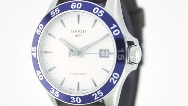 ル・ロックル、スイス15.01.2020 - Tissot男性はステンレススチールケース、ホワイトクロックフェイスダイヤル、レザーストラップ、スイスのクォーツ機械式時計を絶縁、スイスは、製造回転スタンドクローズアップを製造見て — ストック動画