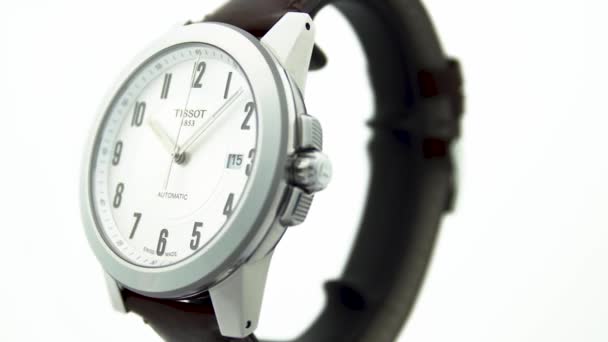 Le Locle, Switzerland 15.01.2020 - Tissot man watch stainless steel case, white clock face dial, leather strap, swiss quartz Machine watch isolated, swiss made making rotation stand up — 비디오