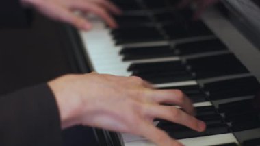 Yetişkin bir adam lüks bir otel restoranında bir piyanoda klasik kompozisyon çalıyor..