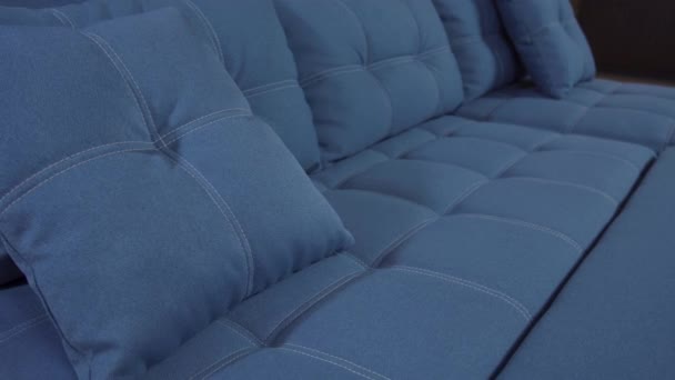 Almohadas de diseño minimalista azul decorativo cuidadosamente se encuentran en un sofá elegante — Vídeo de stock