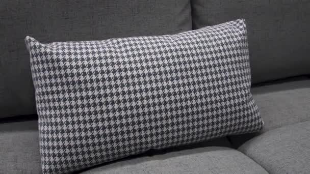 Um travesseiro cinza macio com um padrão minimalista fica no sofá — Vídeo de Stock
