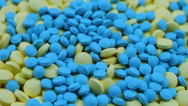 Kleine blauwe voedingssupplementen zijn verspreid over gele antidepressiva. — Stockvideo