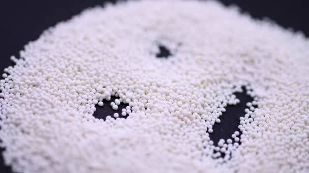 The face is laid out of white granules on a black background. Closeup rotation — Stock Video