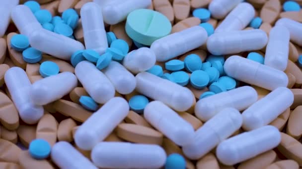 Bright multi-colored painkillers white capsules lie together. Close up rotation — Stock Video