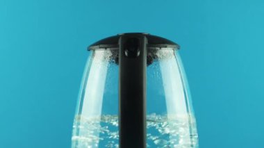 Şeffaf duvarları olan elektrikli bir çaydanlık. Kaynama işlemi. Değiştir. Yakın plan.