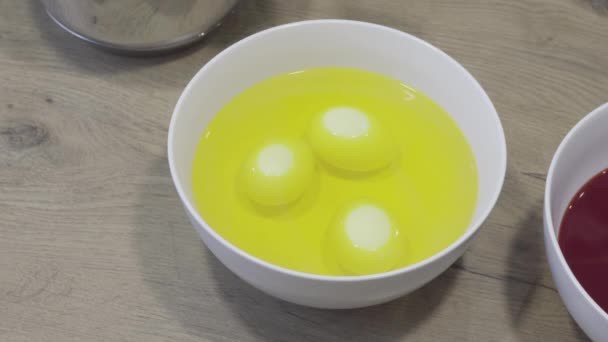 Easter eggs dyeing, dipping in yellow color. Simple holiday decoration tricks — Stock Video