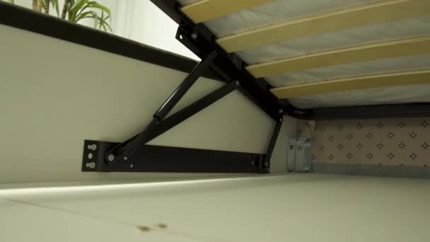 Mecanismo de metal preto abre compartimento de armazenamento na cama — Vídeo de Stock