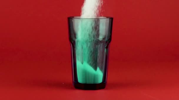 Versare lo zucchero verde collins vetro fondo spesso rosso brillante sfondo slow motion — Video Stock