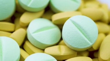 Büyük yuvarlak yeşil haplar parlak sarı antibiyotiklerin üzerinde yatar. Döndürmeyi kapat