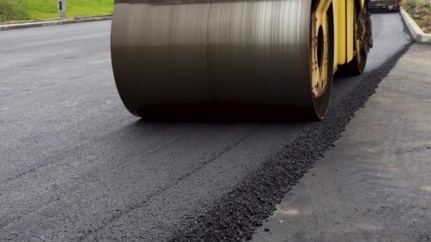A large yellow steamroller flatten hot asphalt. Builds a new road — Stock Video
