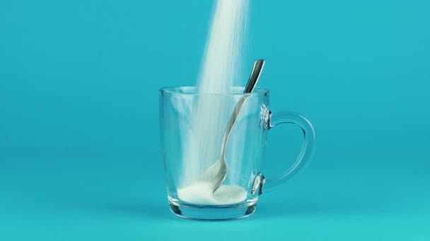 Verser la tasse de sucre cuillère en verre fond épais bleu contrastant concept de fond — Video