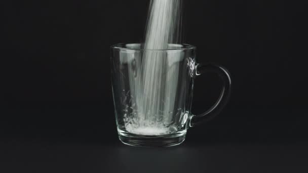 Versare lo zucchero tazza di vetro fondo spesso sfondo nero a contrasto. Concetto — Video Stock