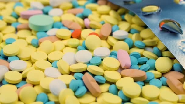 Bright multi-colored medicines lie with an open blister of painkillers. — Stock Video