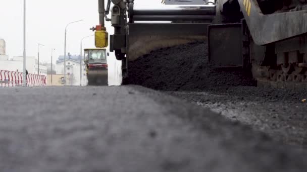 Crawler bouwt nieuwe weg. Een grote en zware apparatuur plat heet asfalt. — Stockvideo