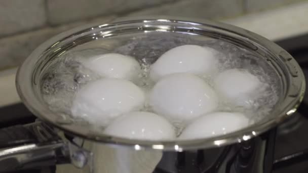 Huevos de pollo en olla con agua hirviendo en estufa de gas. Desayuno cocina — Vídeo de stock