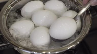 Tavuk yumurtası, tavada kaynar su. Mutfakta yumurta pişiriyorum. Odaklanma