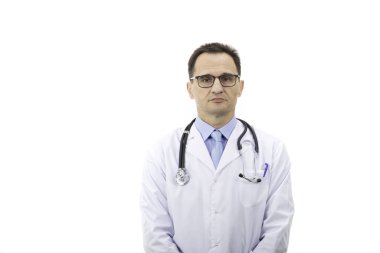 Beyaz önlüklü bir terapist beyaz arka planda kameraya bakıyor.