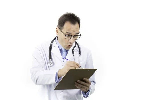 충격을 받은 의사는 클립보드 위에서 환자의 의료 기록, 백인 배경을 확인 한다 — 스톡 사진