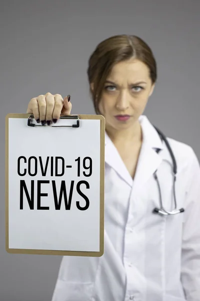 Arrabbiato nurce femminile mostra appunti Covid-19 Notizie, coronavirus concetto statictic — Foto Stock