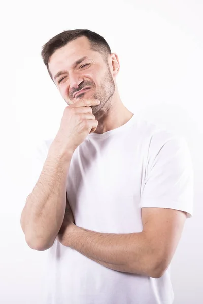 Kaukasischer Mann, der in die Kamera schaut. Hand aufs Kinn. Weißer Hintergrund — Stockfoto