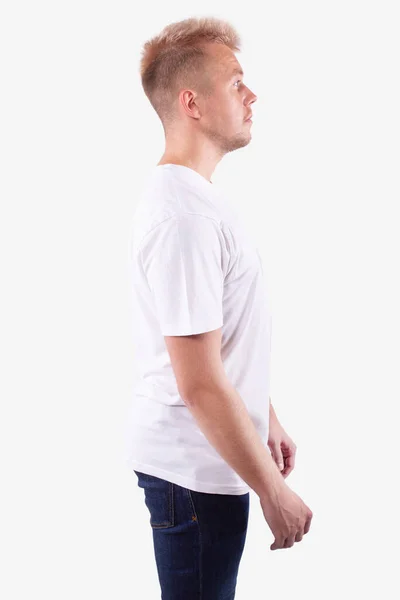 Καυκάσιος στέκεται πλάγια στην κάμερα και κοιτάει μπροστά. Λευκό φόντο — Φωτογραφία Αρχείου